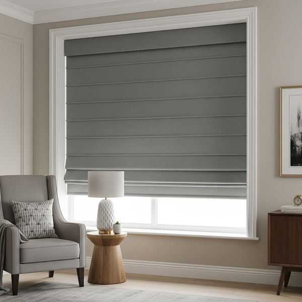Gray roller blinds covering a window in a room with a chair, lamp, and side table.