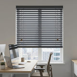 Manufactured dark grey blinds covering a window in an office setting.