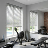 Custom cut to size light grey wood window blinds in a modern home gym